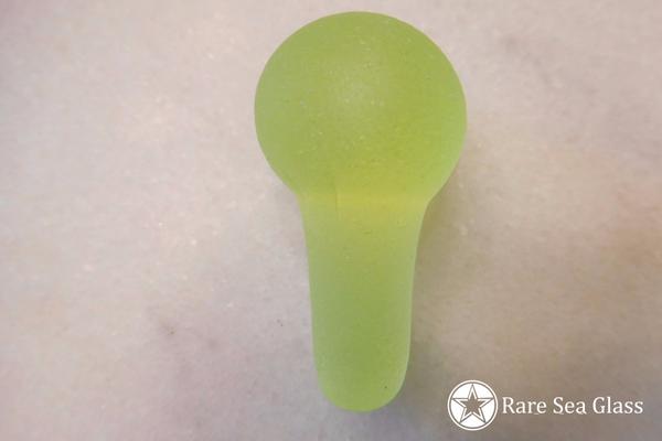 Rare UV sea glass mushroom glowing under ultraviolet light