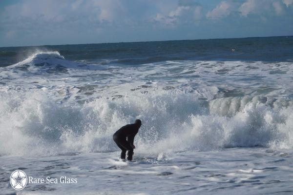 Waves crashing at Davenport Beach where sea glass hunters scoop through gravel in the surf