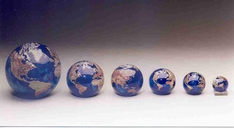 Cobalt blue Lundberg Studios world globe paperweight showing brown continents against deep blue glass